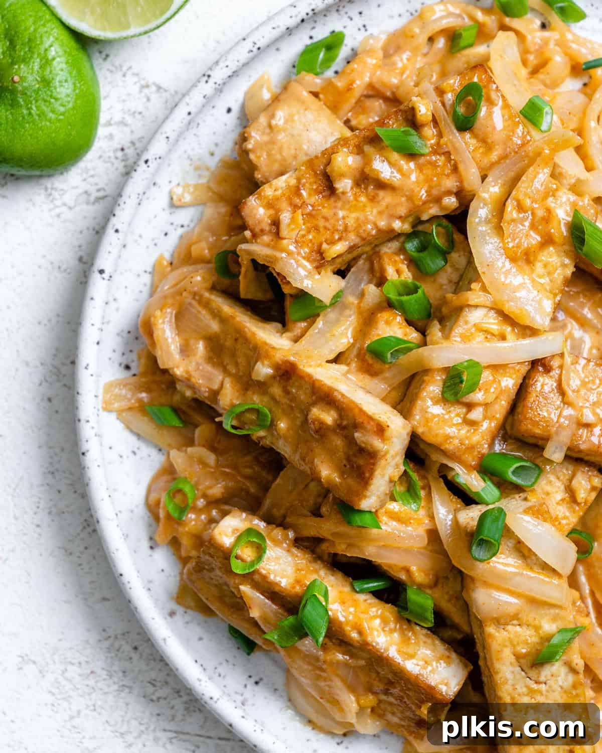 Island-Spiced Tofu with Coconut Lime Drizzle 2 Completed Spicy Tofu with Coconut Lime Sauce on a plate, garnished with fresh herbs.