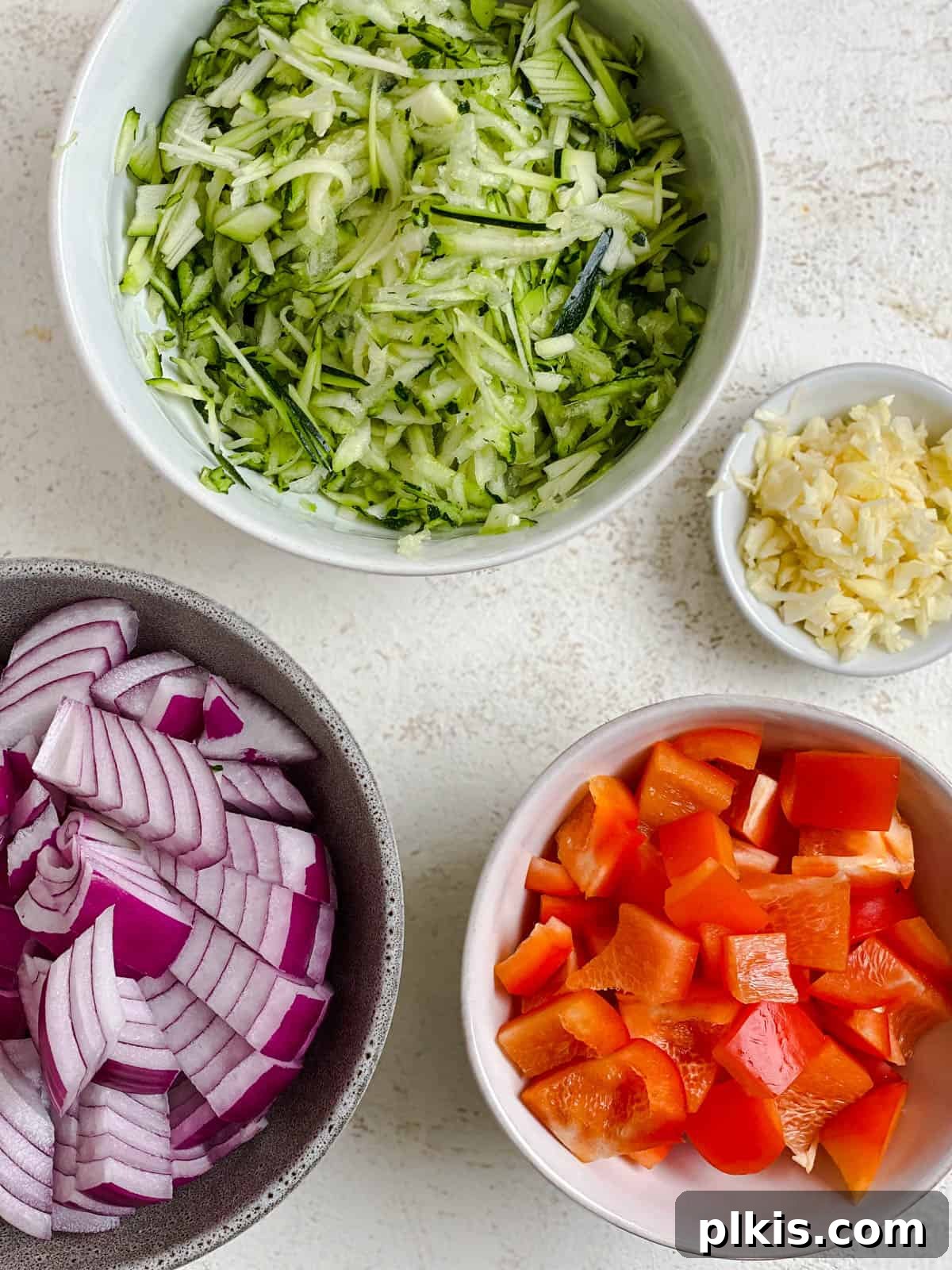 Various ingredients for Vegan Bean Chili [Slow Cooker, Instant Pot, Stove] prepped and measured out on a white surface, showcasing the freshness and readiness for cooking.