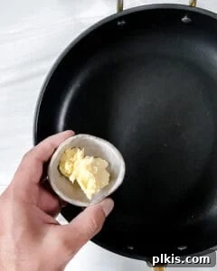 Vegan butter being added to a hot pan, preparing for the glaze.