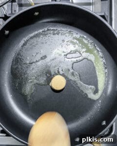 Vegan butter beginning to melt and bubble in the pan with brown sugar.