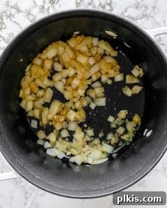 Velvet Mushroom Elixir 6 Onions, garlic, and oil gently sizzling in a black stockpot, building the soup's aromatic base.
