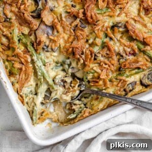 Completed Dairy-Free Green Bean Casserole in a white baking dish with crispy onions.