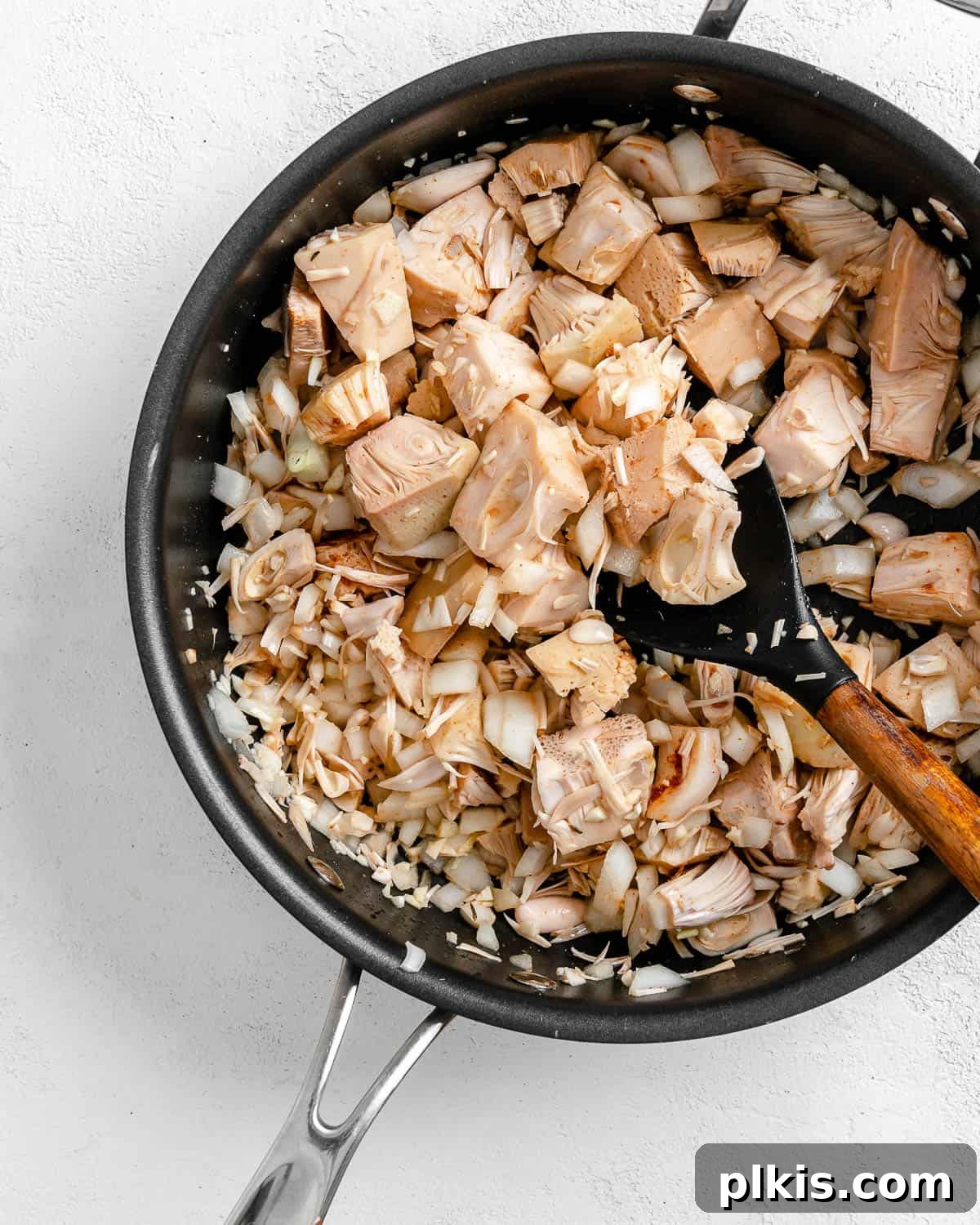 Smoky Vegan Jackfruit BBQ 10 process of mixing jackfruit and spices in a black pan against white background