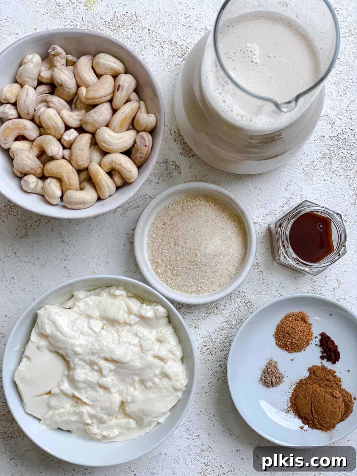 Effortless Dairy-Free Eggnog 3 All the ingredients for Easy Vegan Eggnog, precisely measured and artfully arranged on a pristine white surface, ready for blending.