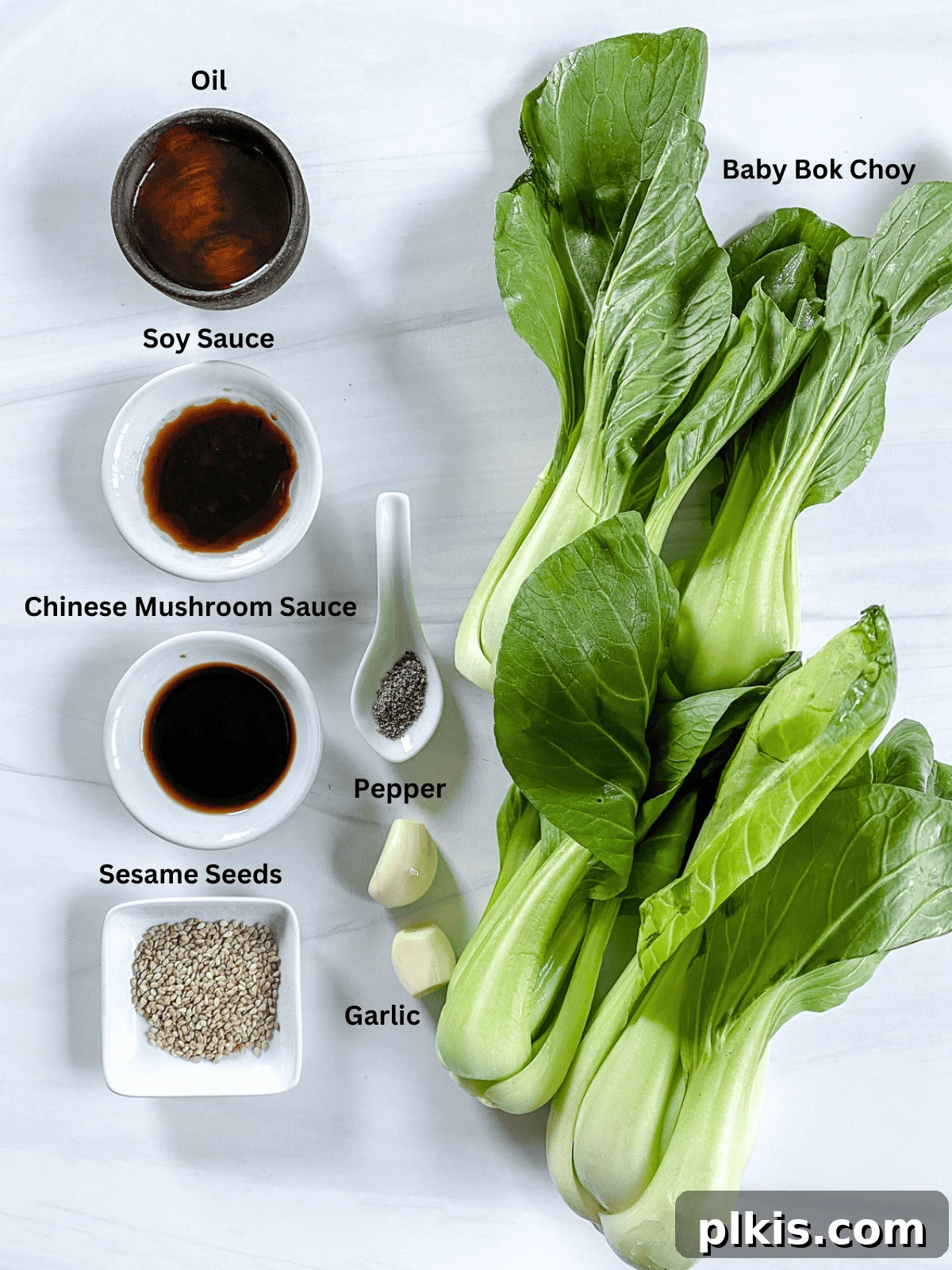 Garlic Soy Glazed Baby Bok Choy 3 All the fresh ingredients and measured condiments for Baby Bok Choy with Soy Sauce and Garlic laid out on a clean white surface, showcasing their freshness and readiness.