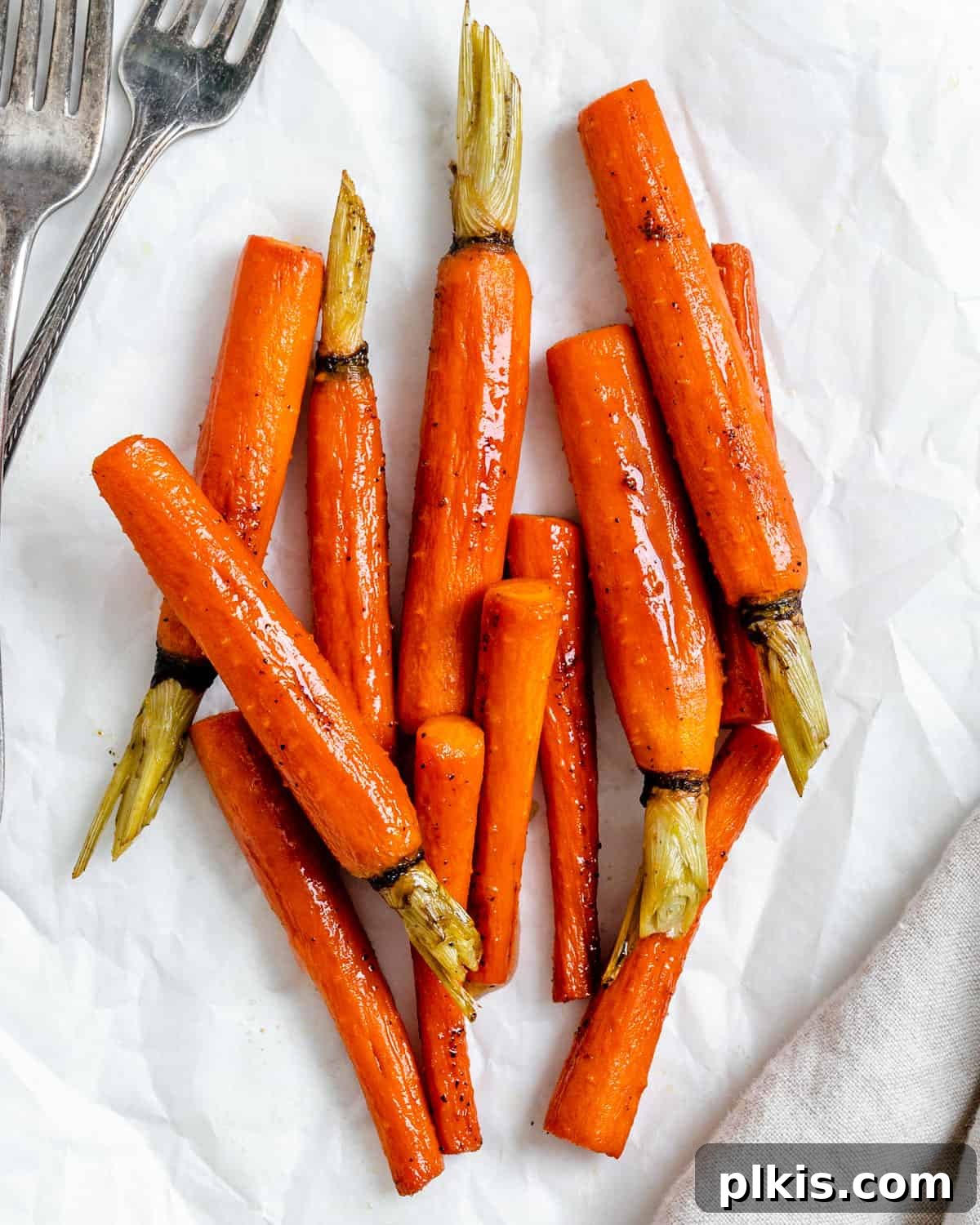 Mastering Glazed Carrots and Their Delicious Flavor Variations 2 Vibrant glazed carrots, perfectly cooked and glistening, served in a bowl on a clean white surface, ready to be enjoyed as a festive side dish.