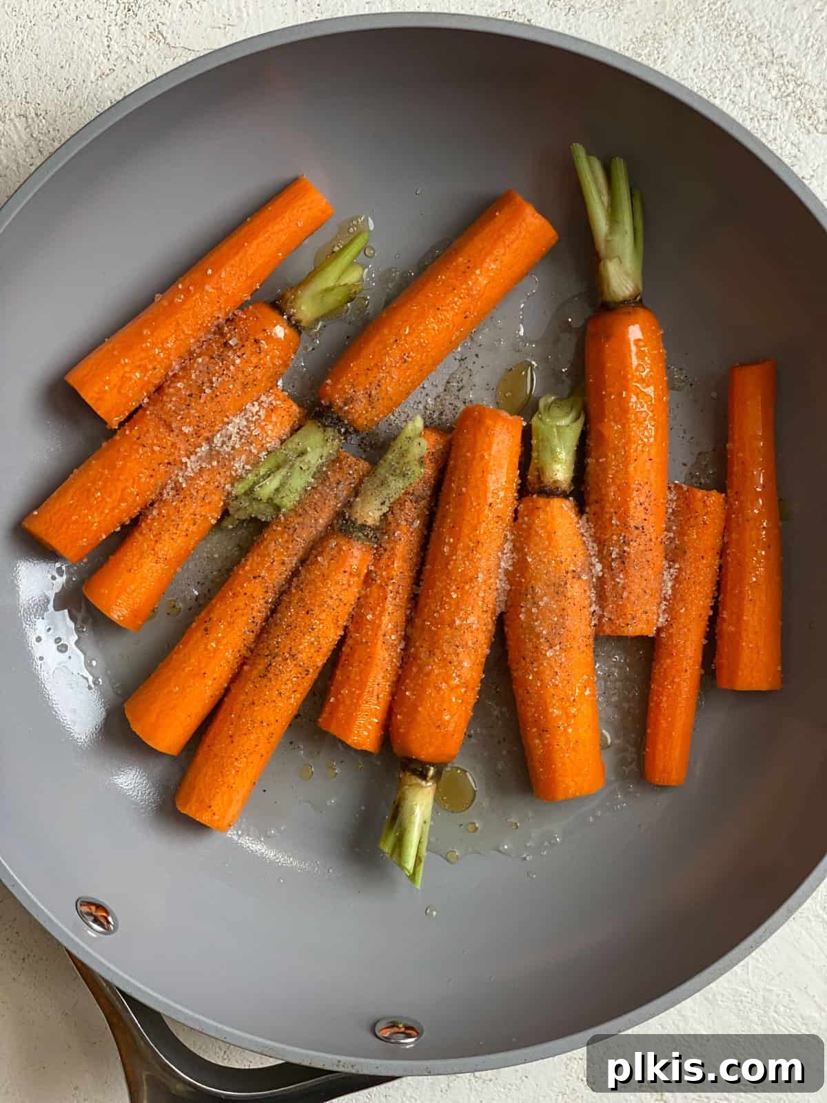 Mastering Glazed Carrots and Their Delicious Flavor Variations 7 A third process image showing the carrots fully submerged in the simmering glaze within the skillet, with all ingredients combined.