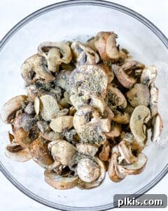 Perfect Roasted Mushrooms With Flavor Twists 4 mushrooms in a bowl with seasonings before mixing