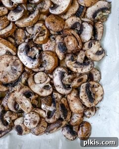 Perfect Roasted Mushrooms With Flavor Twists 7 seasoned mushrooms spread on a baking tray before roasting