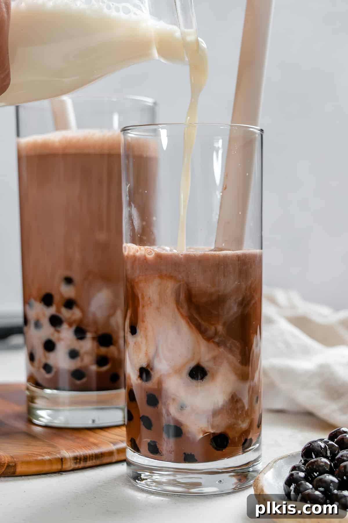 Velvet Chocolate Tea 2 Two glasses of completed Dairy-Free Chocolate Milk Tea with boba, garnished with chocolate shavings.