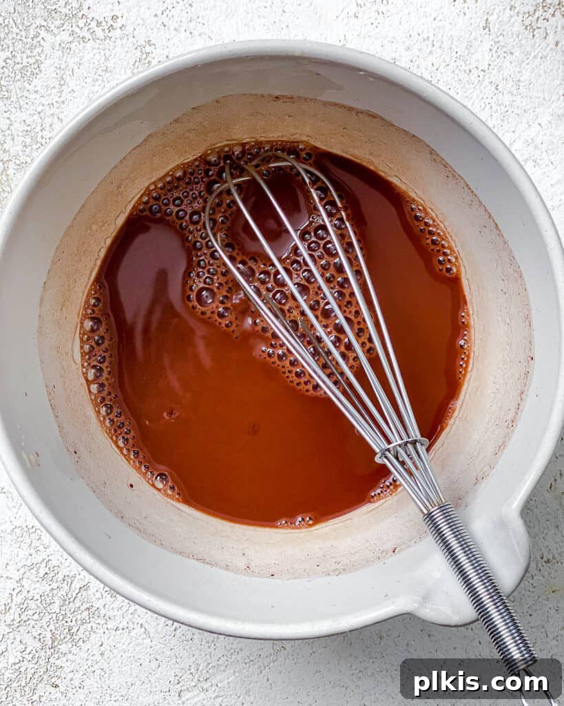 Velvet Chocolate Tea 6 Process shot of whisking cocoa powder, sugar, and tea together in a bowl until smooth.