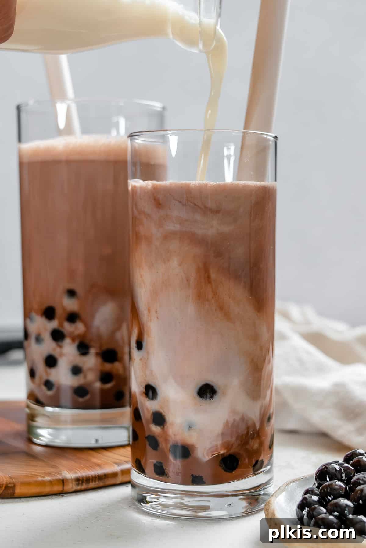 Velvet Chocolate Tea 7 Two aesthetically arranged glasses of finished Chocolate Milk Tea with boba and chocolate garnish.