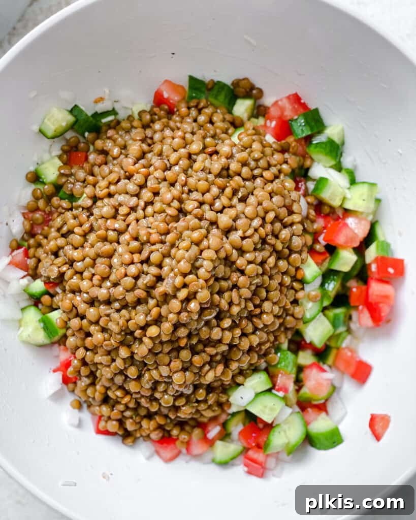 Fresh and Flavorful Lentil Tabbouleh 11 Process shot showing the addition of cooked lentils to the bowl of vegetables.
