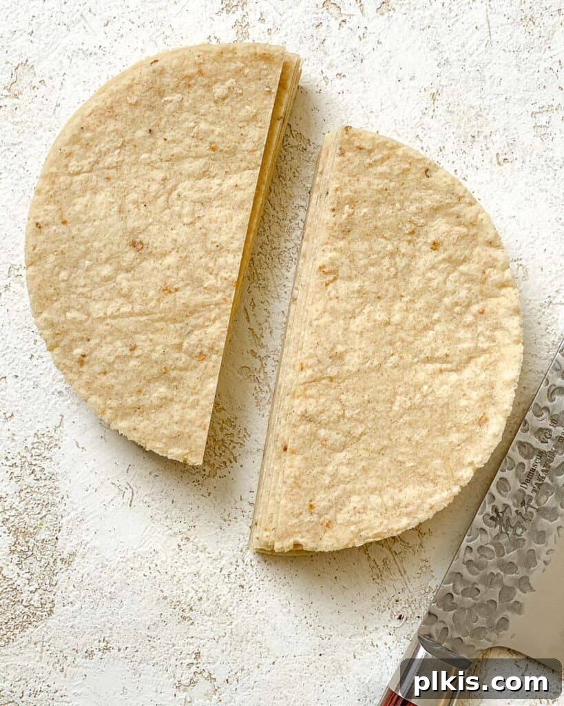 The Crispiest Air Fryer Tortilla Chips 4 corn tortilla sliced into halves against a white surface