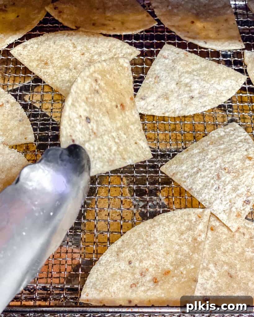The Crispiest Air Fryer Tortilla Chips 9 process shot showing flipping of tortilla chips on air fryer tray