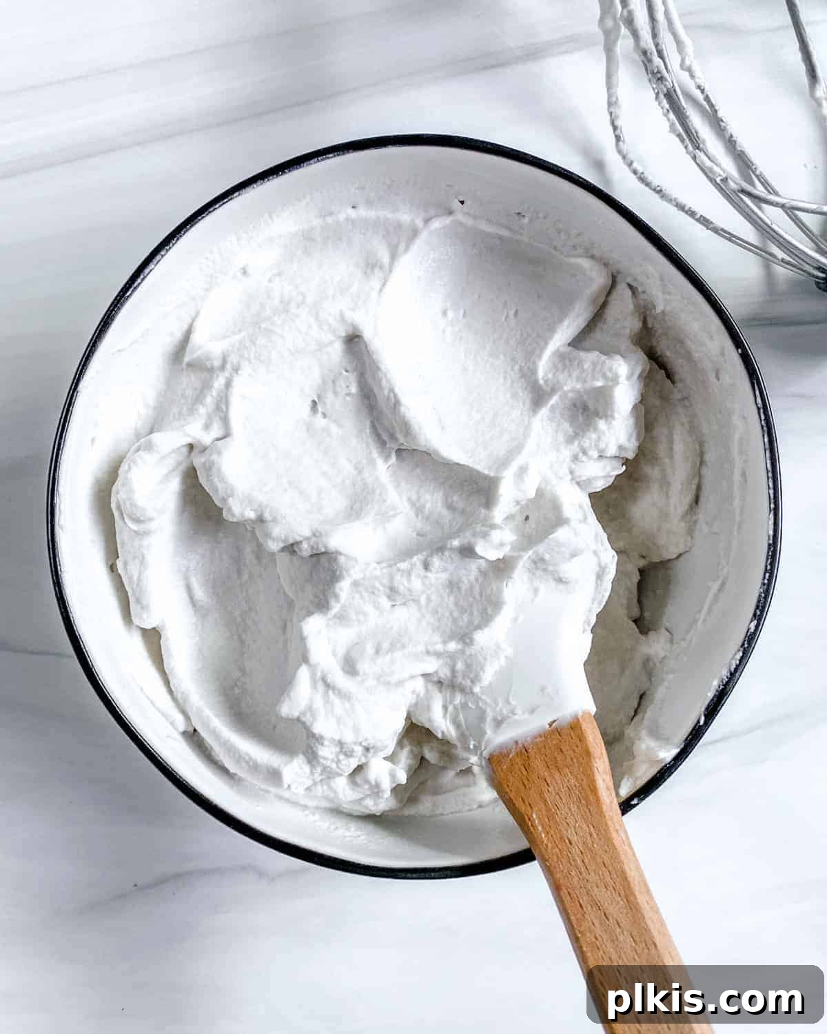 Plant-Based Whipped Topping 2 completed vegan whipped cream with mixing utensil in bowl against white background, ready to be served