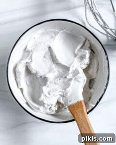 Plant-Based Whipped Topping 5 completed vegan whipped cream with mixing utensil in bowl against white background