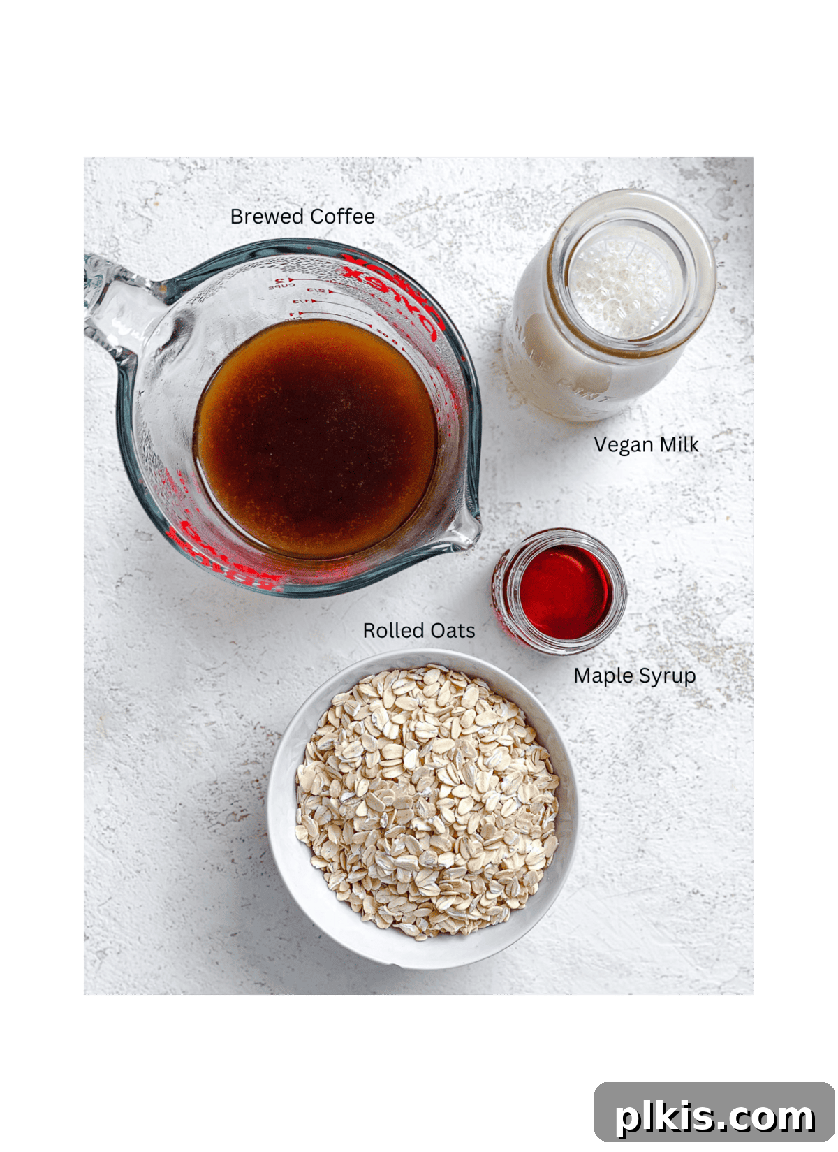 Quick Coffee Oats 3 Individual ingredients for coffee oatmeal, including rolled oats, brewed coffee, plant-based milk, and a sweetener, neatly measured and displayed on a white surface, ready for preparation.
