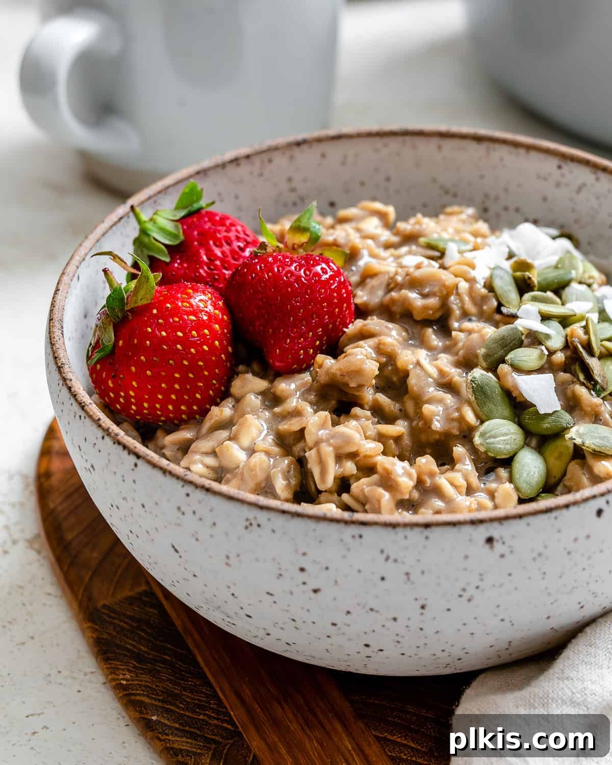 Quick Coffee Oats 7 A close-up of a rustic bowl of coffee oatmeal, featuring visible oat texture, coffee color, and subtle garnishes, presented on a light, textured surface.