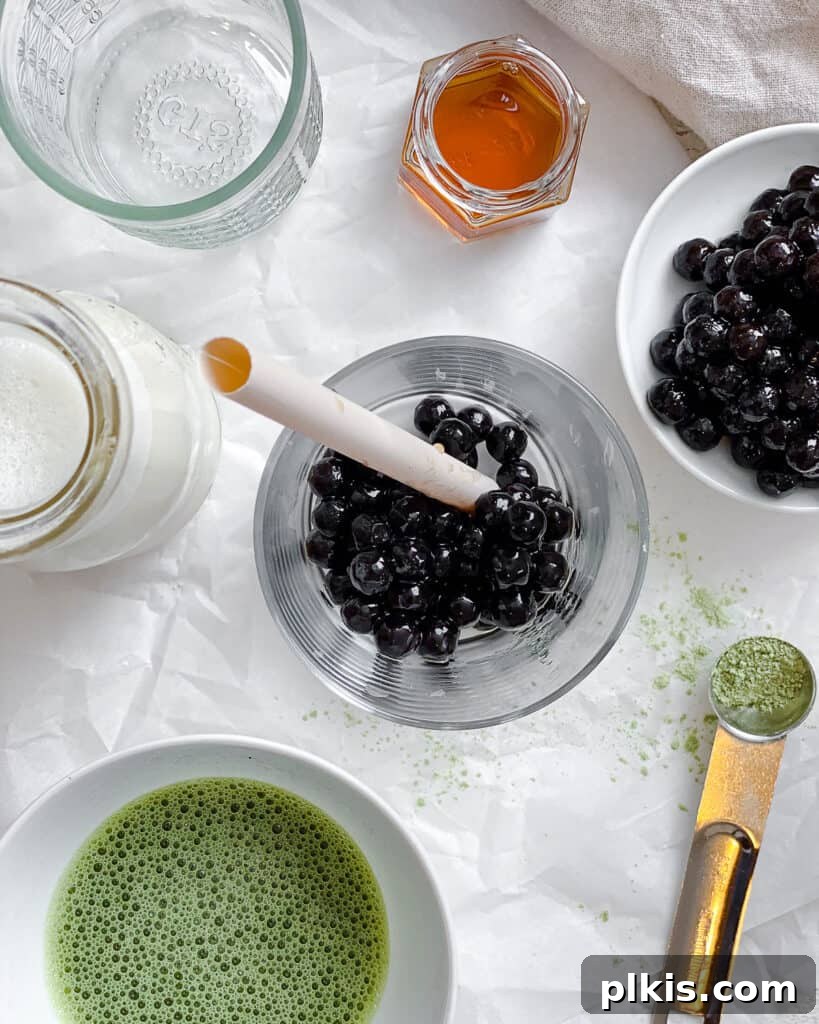 Emerald Creamy Matcha Boba 4 ingredients for Matcha Boba Tea (Green Milk Tea) measured out against a white surface