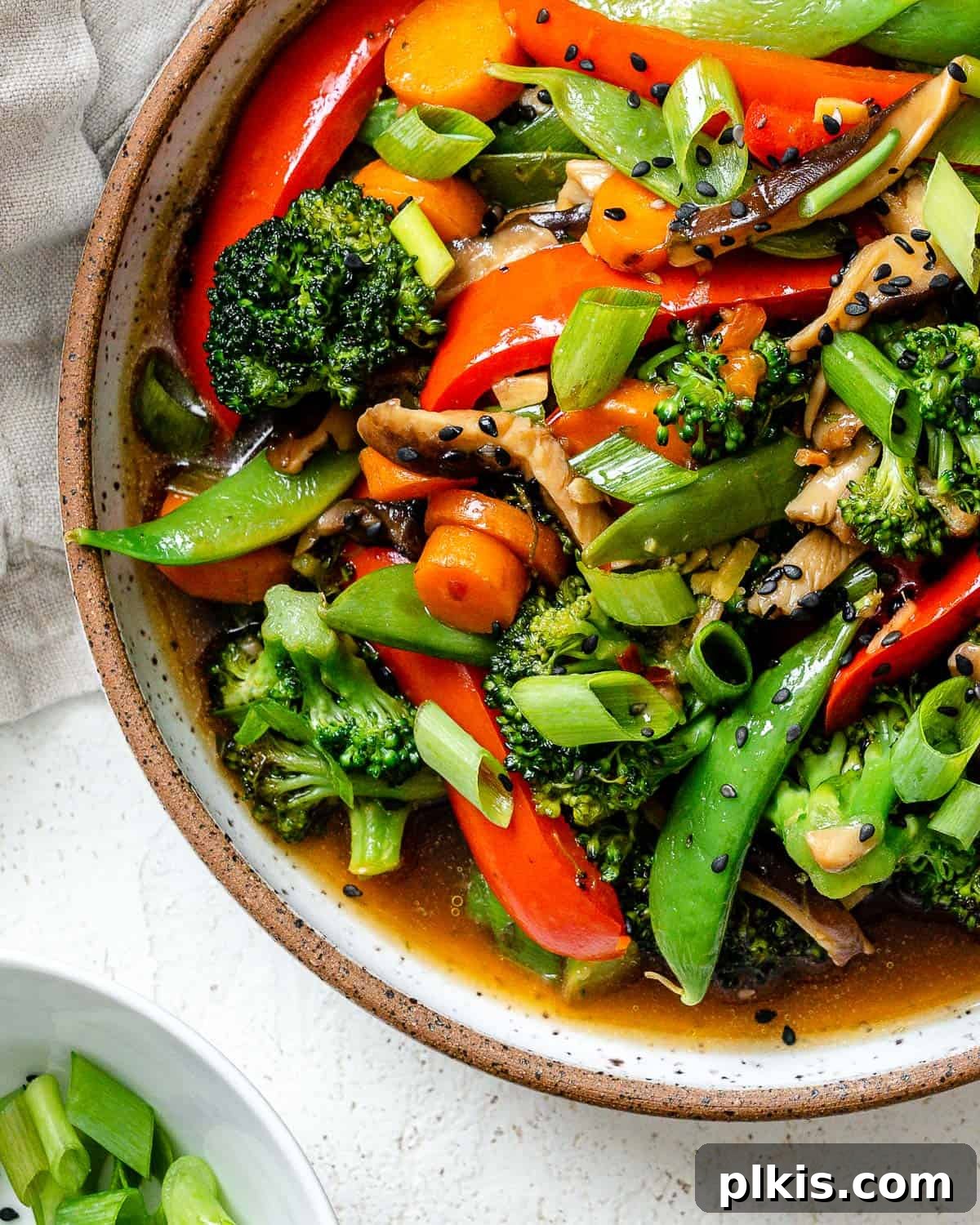 A beautifully plated bowl of Easy Stir-Fry Vegetables, showcasing a colorful mix of tender-crisp veggies coated in a glossy, flavorful sauce, set against a light, inviting background.