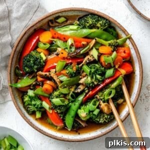 A completed bowl of Easy Stir-Fry Vegetables, showcasing a colorful mix of tender-crisp veggies coated in a glossy, flavorful sauce, set against a light, inviting background.