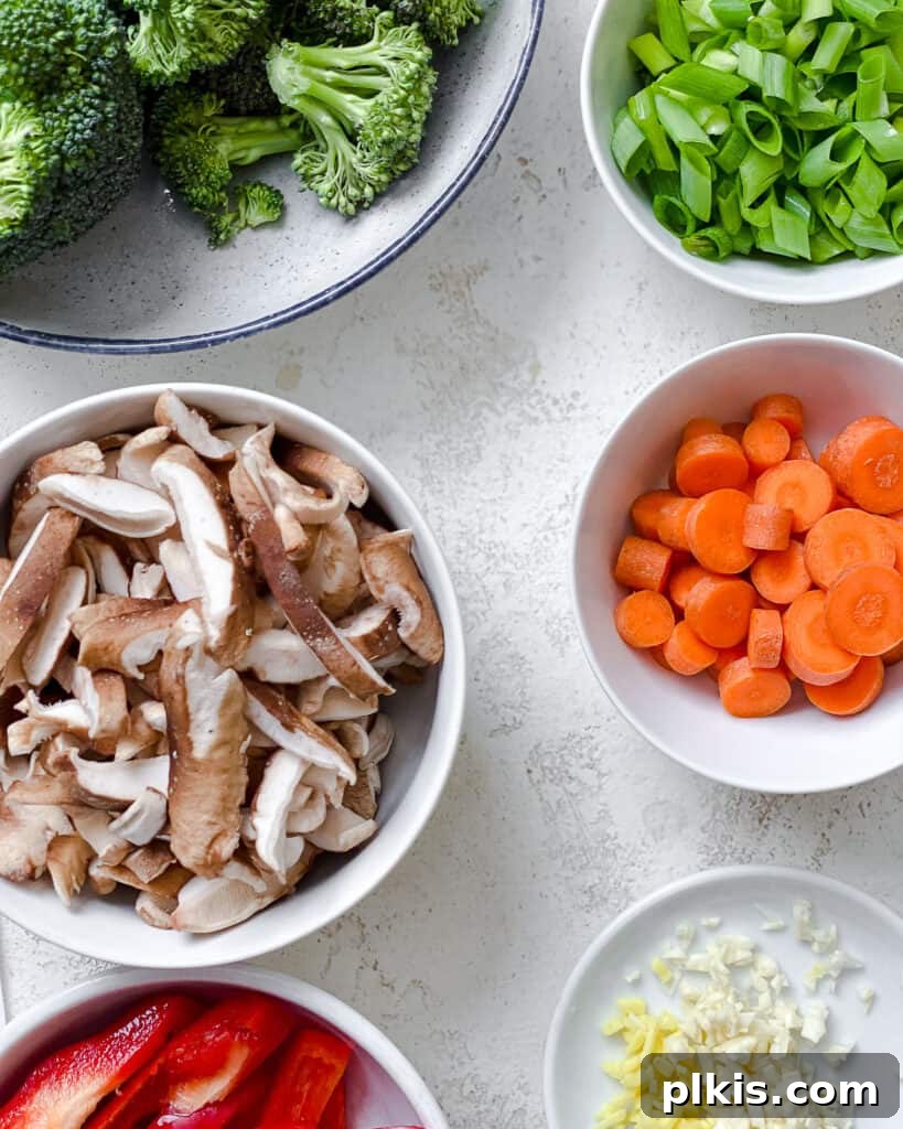 A bowl of fresh ingredients for Easy Stir-Fry Vegetables, neatly chopped and ready to be cooked on a white surface.