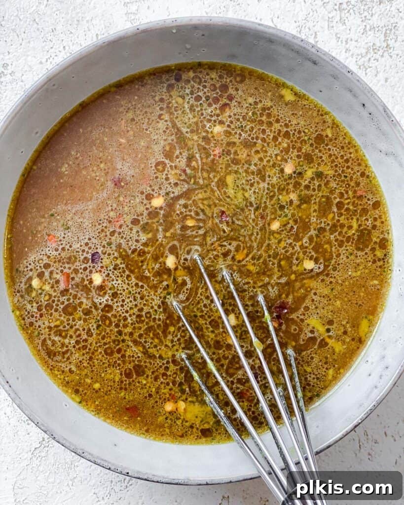 A close-up shot of the stir-fry sauce ingredients being whisked together in a bowl, creating a smooth, cohesive mixture.