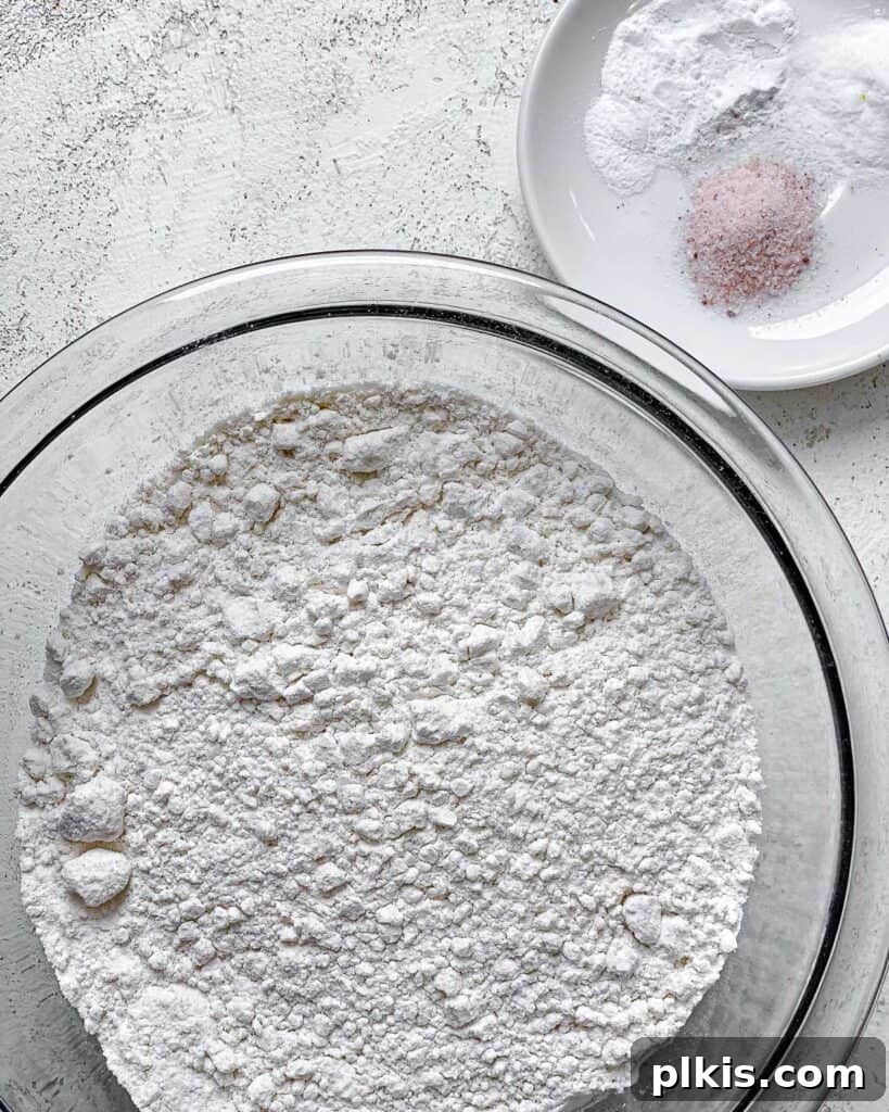 Zesty Vegan Lemon Shortbread 13 A bowl of flour positioned alongside a smaller bowl containing salt, baking powder, and baking soda.