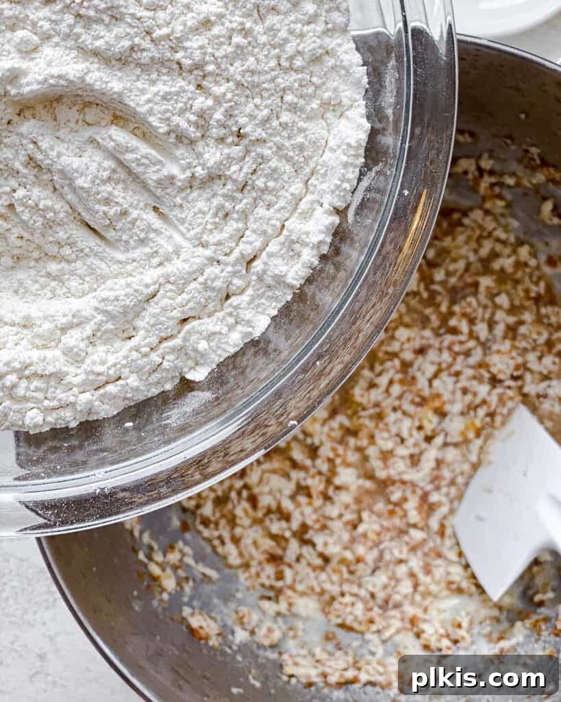 Zesty Vegan Lemon Shortbread 14 Process shot of gradually adding flour to the wet ingredients in the bowl.