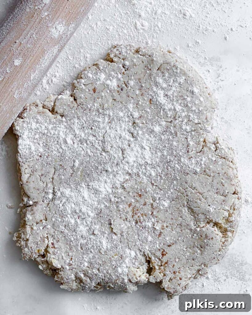 Zesty Vegan Lemon Shortbread 17 Process shot demonstrating the flattening of the cookie dough against a white background with a rolling pin.