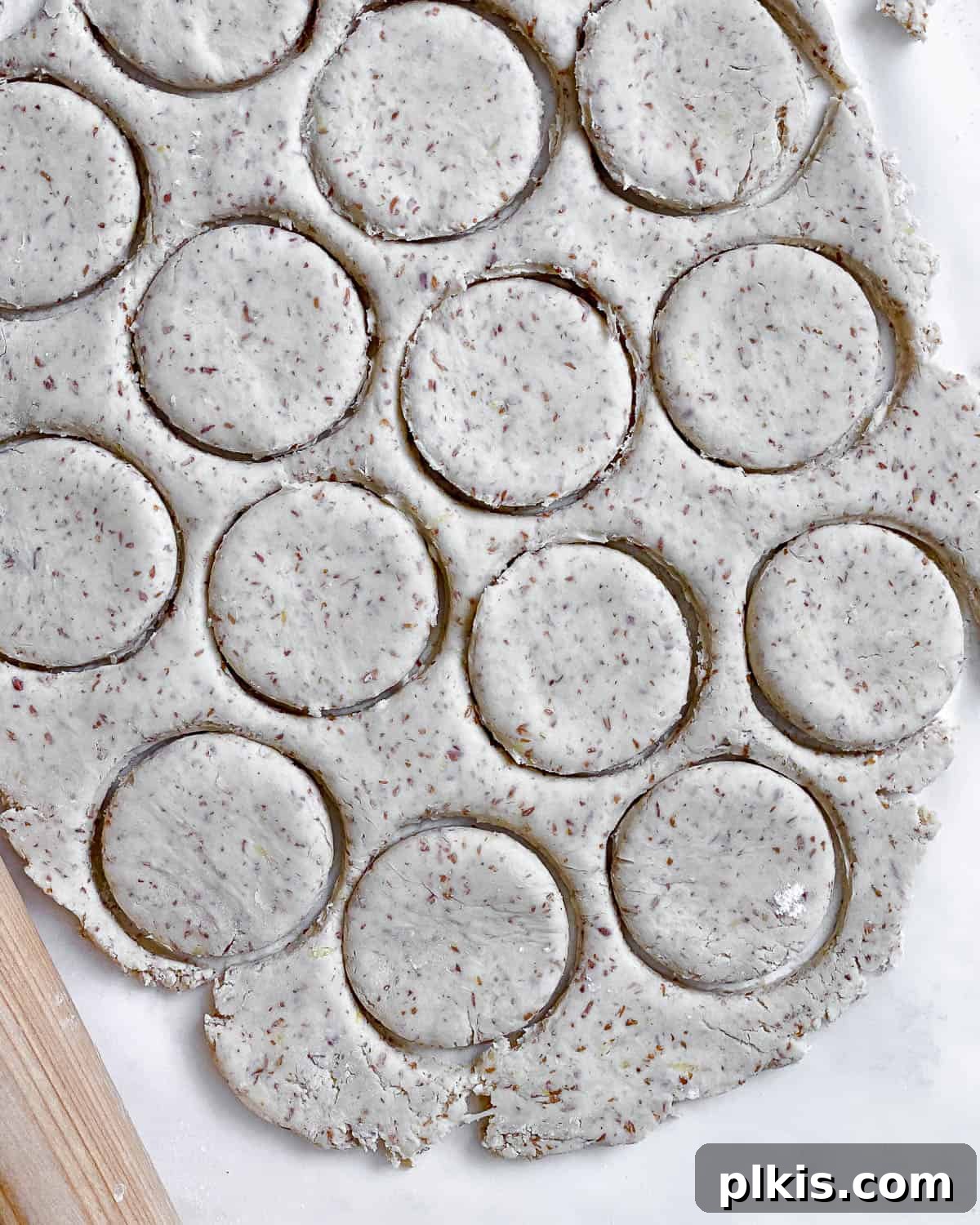 Zesty Vegan Lemon Shortbread 19 Process shot illustrating the creation of circular shapes in the flattened cookie dough using a cookie cutter.