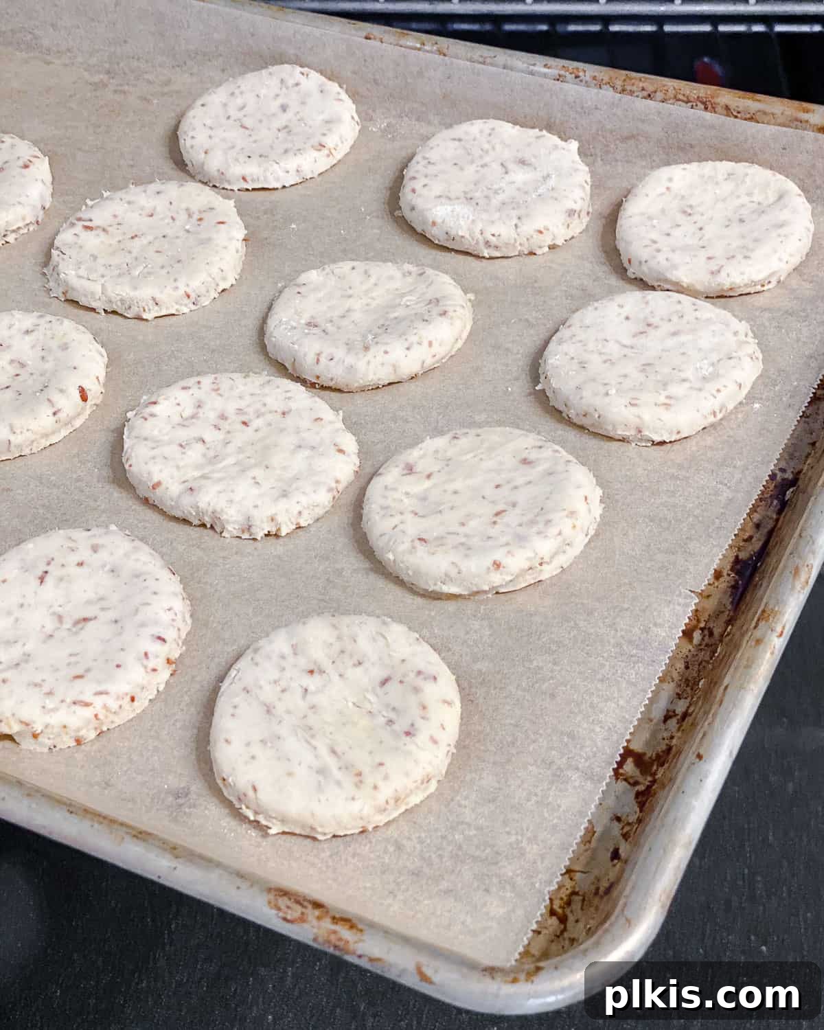 Zesty Vegan Lemon Shortbread 20 Process shot showing cookie dough circles neatly arranged on a baking sheet, ready for the oven.