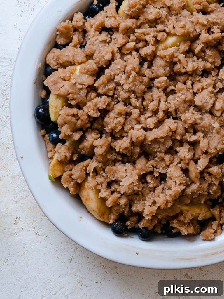 Warm Apple Blueberry Crumble 13 pre-baked apple and blueberry crumble against a white background