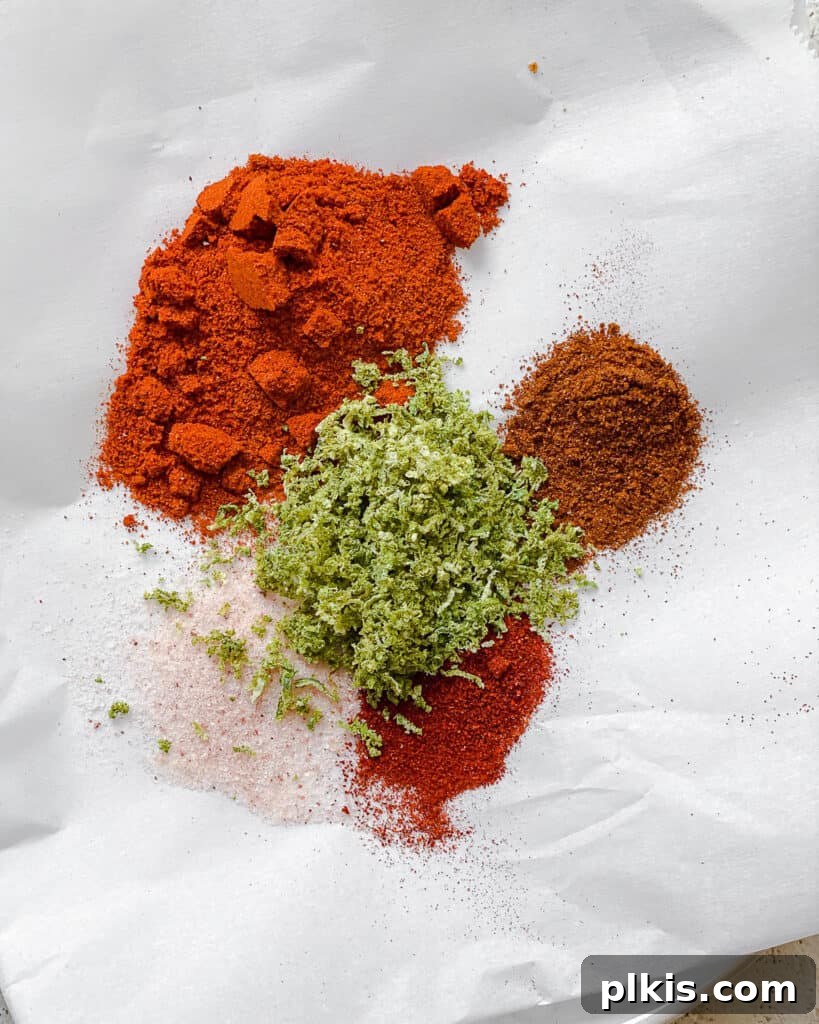 Make Your Own Tangy Chili Lime Dust 7 All the dry ingredients for Homemade Chili Lime Seasoning (Tajin) — including dried lime zest, various chile powders, and salt — are neatly arranged in individual piles on a white surface, ready to be combined into the final spice blend.