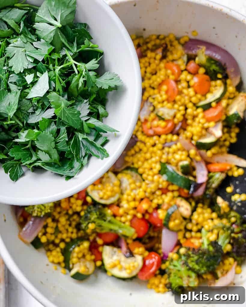 Roasted Garden Couscous Medley 17 Fresh parsley being sprinkled over the combined roasted vegetables and couscous.