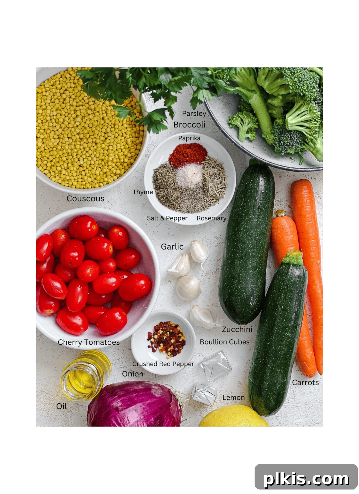 Roasted Garden Couscous Medley 3 Ingredients laid out for Roasted Vegetable Couscous, including broccoli, zucchini, carrots, red onion, tomatoes, couscous, and herbs.