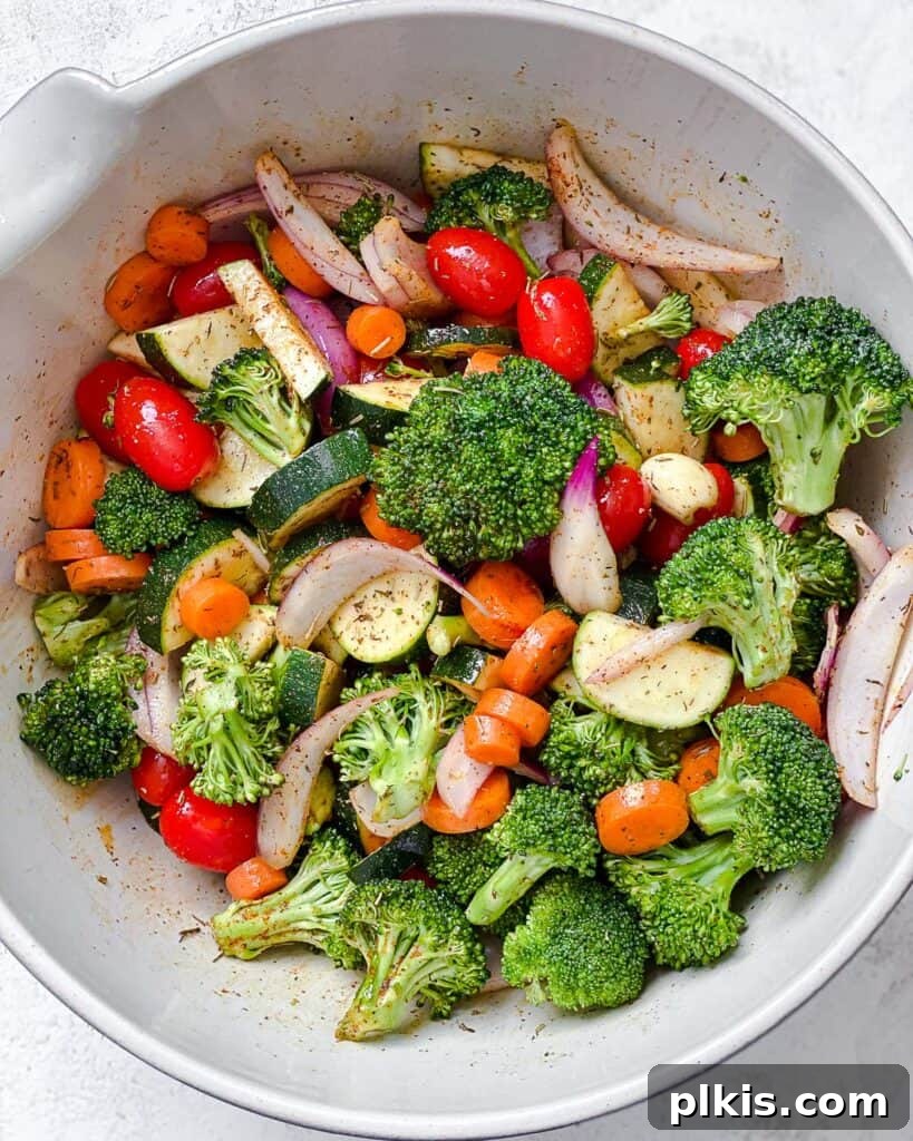 Roasted Garden Couscous Medley 9 Tossed vegetables in a bowl, evenly coated with oil and spices.