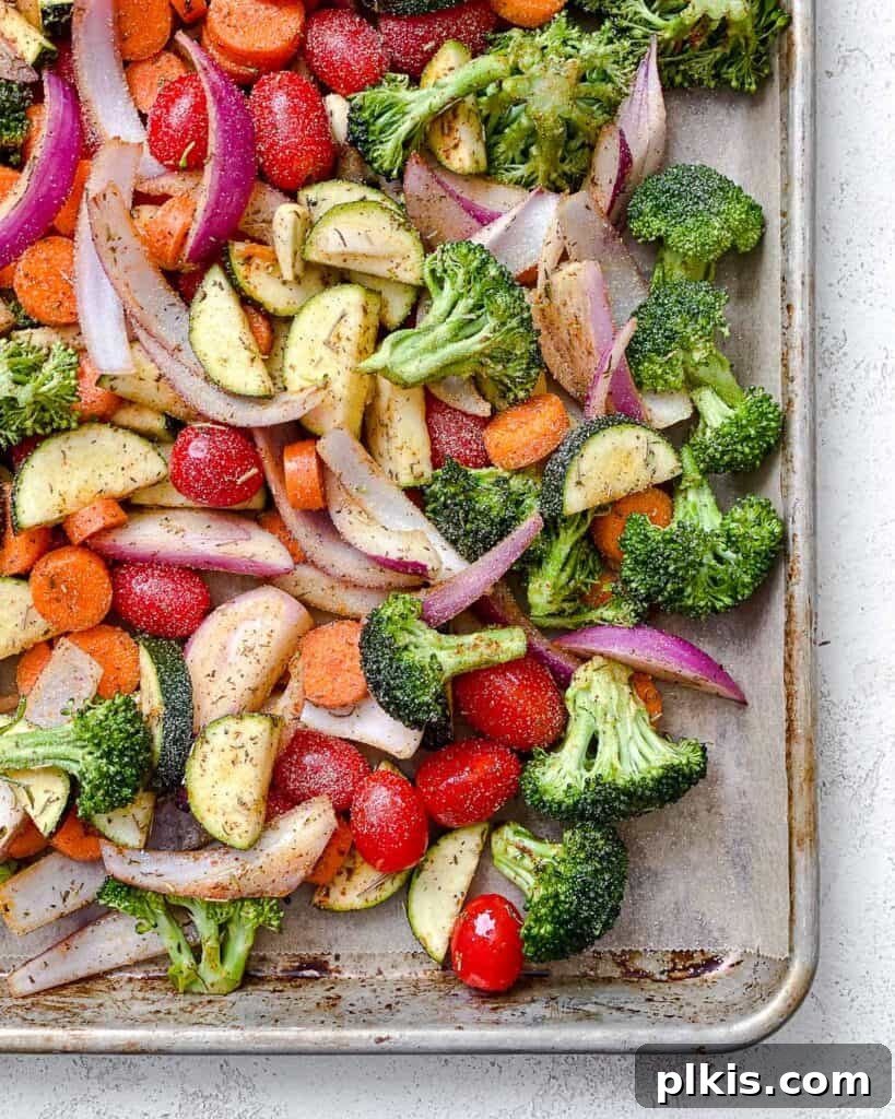 Roasted Garden Couscous Medley 10 Seasoned vegetables spread in a single layer on a baking sheet, ready for the oven.