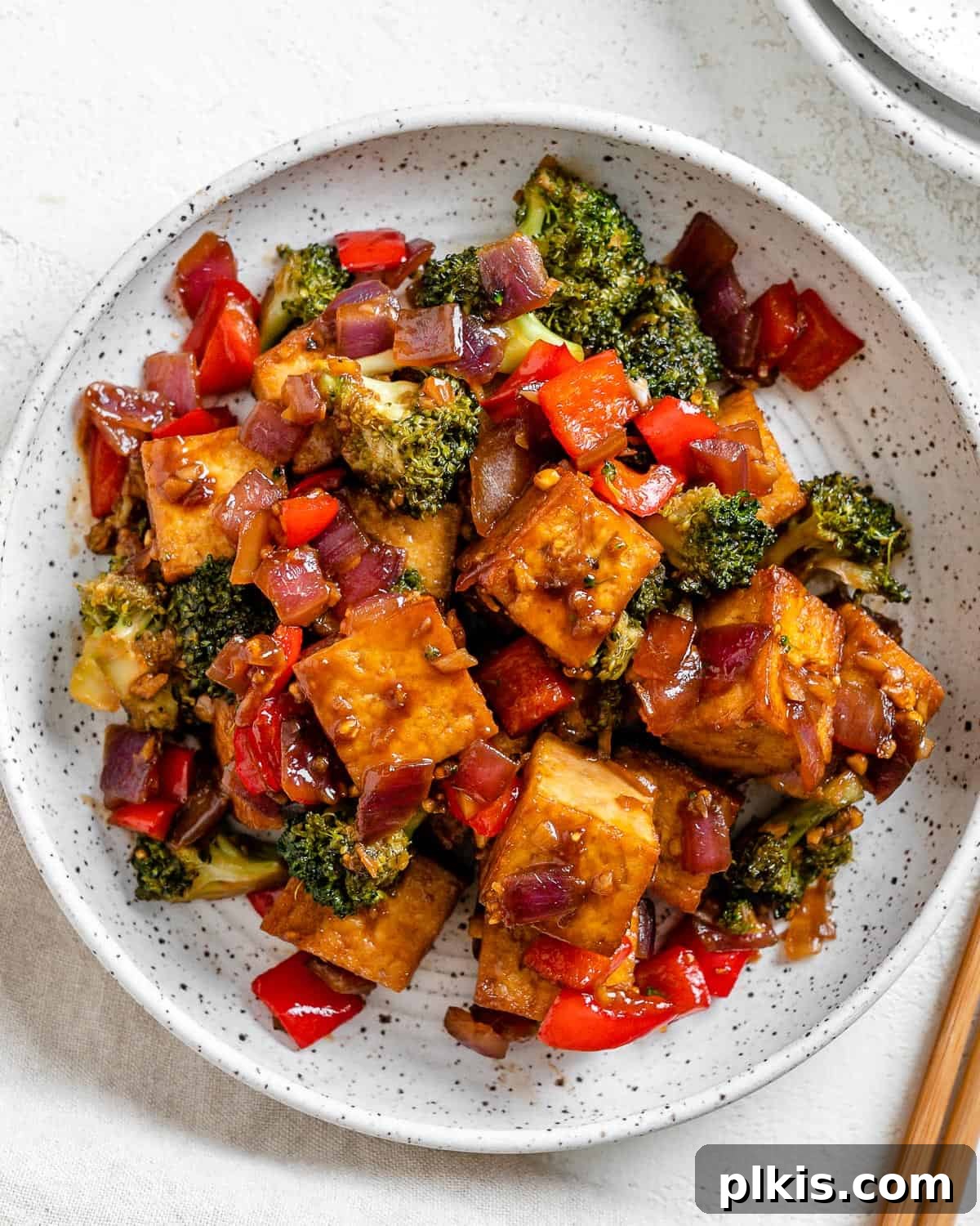 Speedy Teriyaki Tofu Bowl 2 Delicious vegan teriyaki tofu stir-fry with colorful vegetables served in a white bowl against a light surface