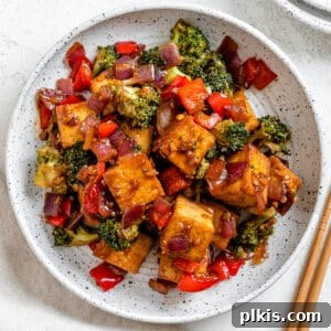 completed Vegan Teriyaki Tofu Stir Fry plated on a white bowl against a light surface