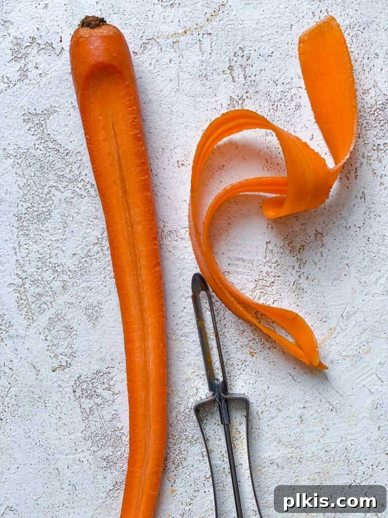 Vibrant Carrot Salad 4 process shot showing peeling of carrots against white surface