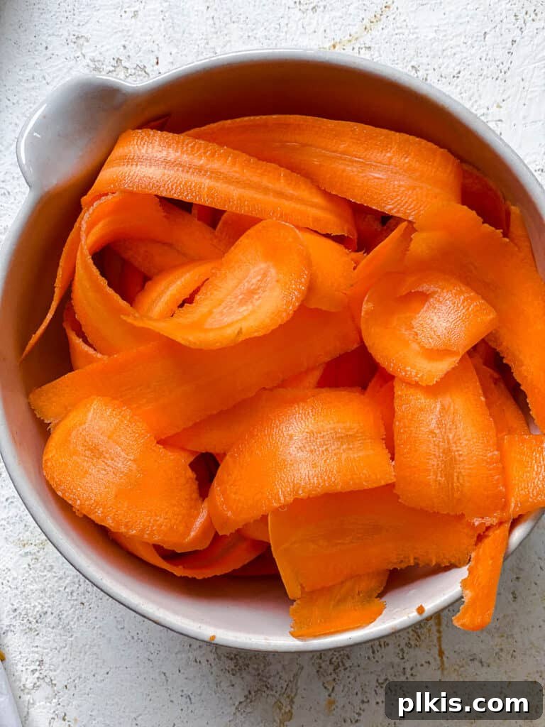 Vibrant Carrot Salad 5 peeled carrots in a white bowl