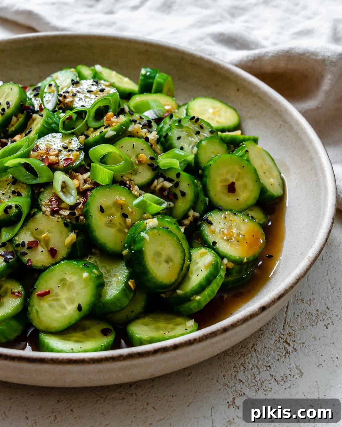 Sassy Cucumber Slaw 6 Close-up of completed Spicy Asian Cucumber Salad plated on a white plate, showcasing its vibrant colors and crisp texture.