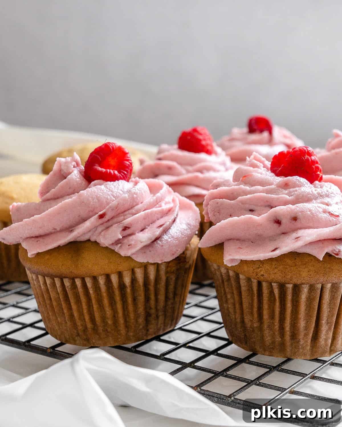 Simple Raspberry Cupcakes Your Way 2 completed raspberry cupcakes on wire rack