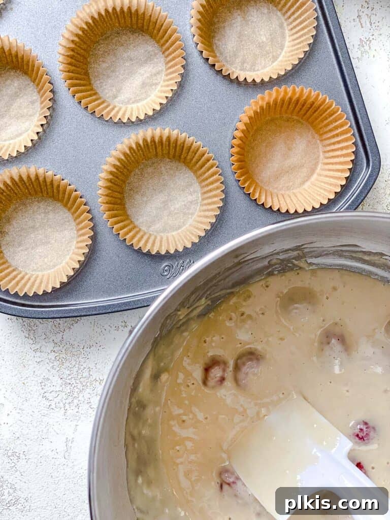 Simple Raspberry Cupcakes Your Way 7 process shot of adding cupcake batter to muffin tin