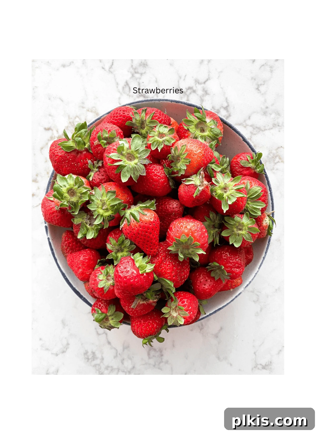 Refreshing Strawberry Juice Recipe 3 A bowl overflowing with vibrant, ripe red strawberries, symbolizing the fresh main ingredient for homemade strawberry juice, set against a pristine white background.