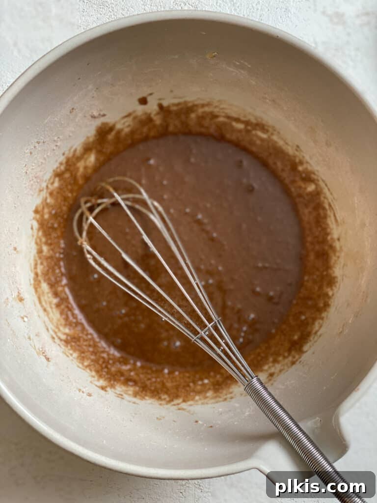 Zucchini Apple Pie Surprise 6 Ingredients for Vegan Zucchini Mock Apple pie filling being stirred in a bowl, showing the blend of sugars, cornstarch, and spices.