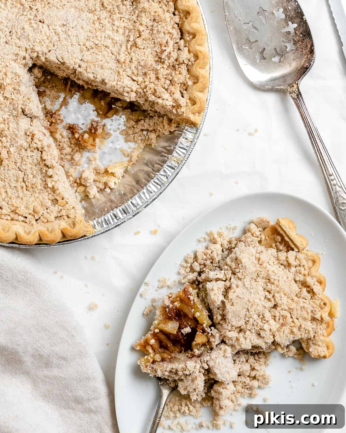 Zucchini Apple Pie Surprise 10 Completed Vegan Zucchini Mock Apple Pie with a slice plated on a white plate against a light background, highlighting its golden-brown topping and rich filling.