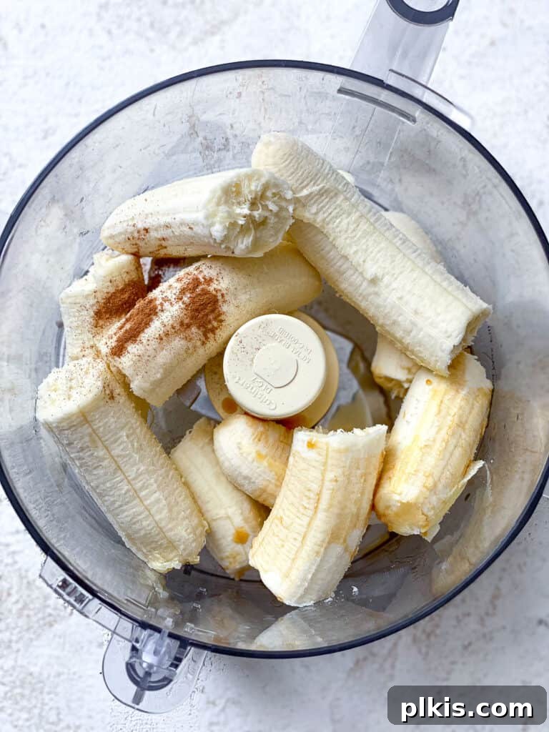 Naturally Sweet Banana Pops 4 Process shot showing ripe bananas and other ingredients being added to a food processor for blending.